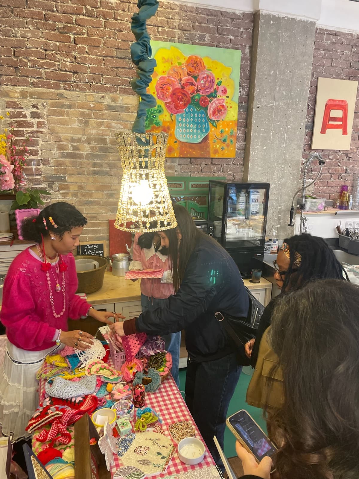 Three customers reaching across a crochet stall while the maker serves them